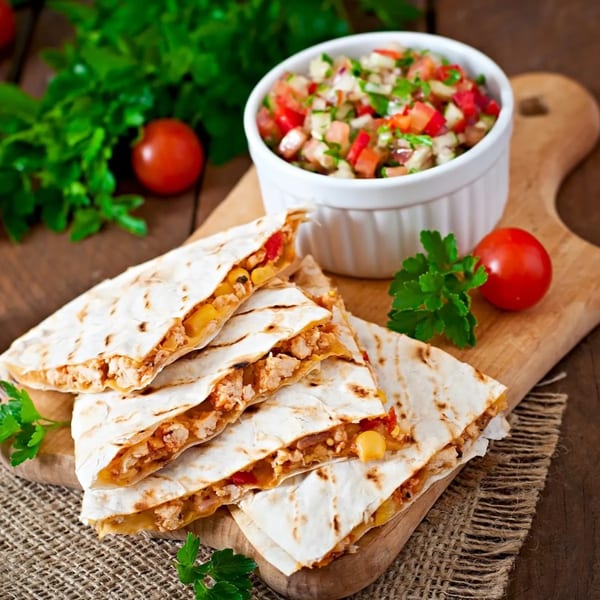 Chicken quesadillas with corn and red peppers, served with fresh salsa and cherry tomatoes.